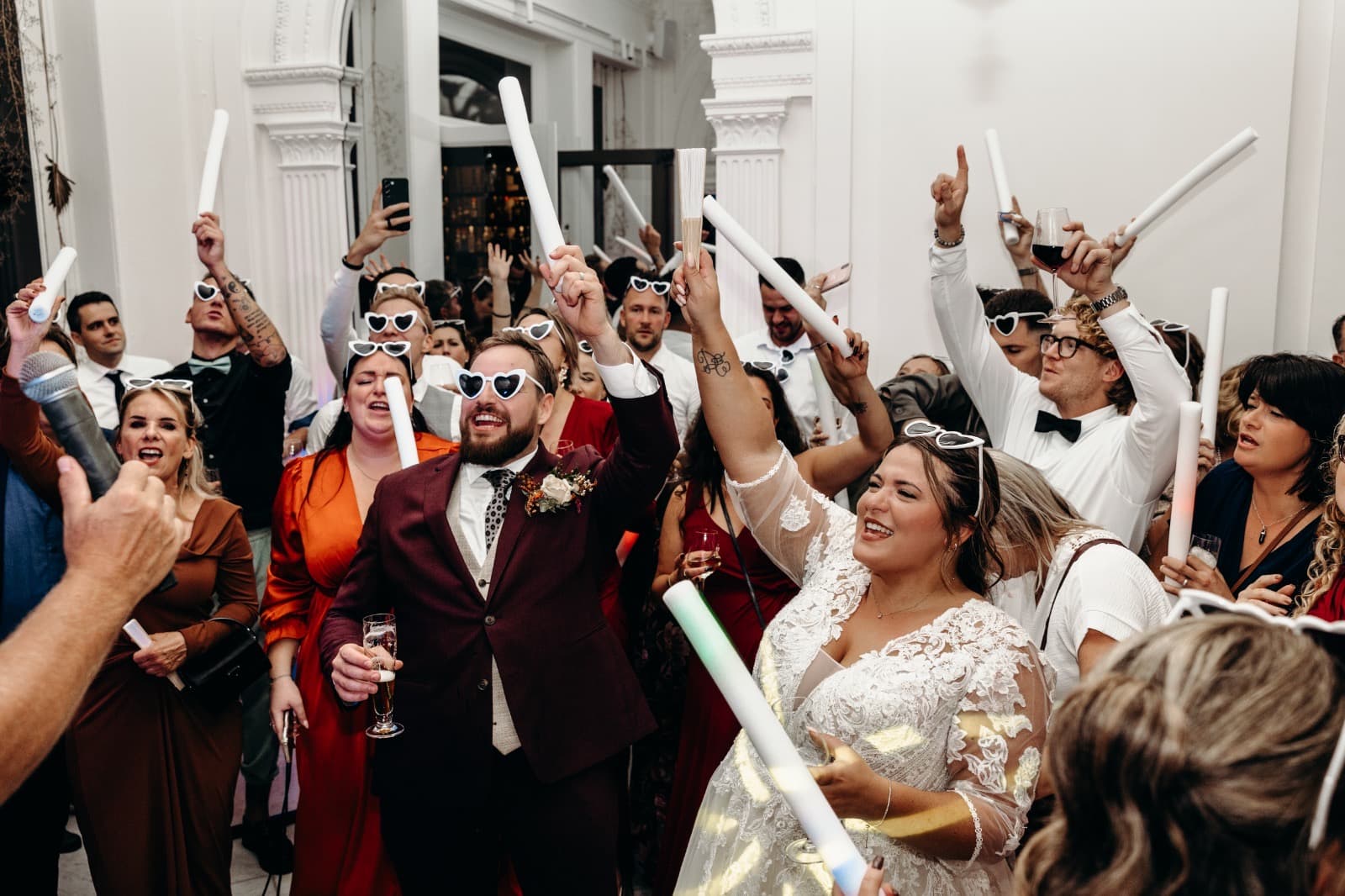 Bruidspaar danst onder warme verlichting op hun bruiloft